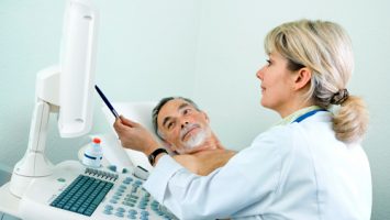 A NorthWest Cardio Diagnostics ultrasound technician showing a patient the medical imaging of their ECG and carotid ultrasound.